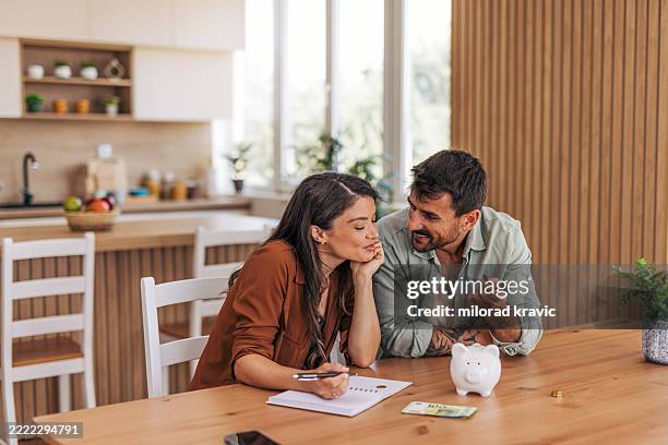 couple doing finances and budgeting at home - financial accessory stock pictures, royalty-free photos & images
