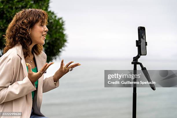 influencer creating content on a boardwalk, seeking inspiration - stativ stock-fotos und bilder