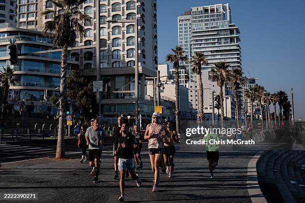 People run along the beach promenade on June 27, 2025 in Tel Aviv, Israel. As Israel's government touts its victory over Iran after 12 days of war,...