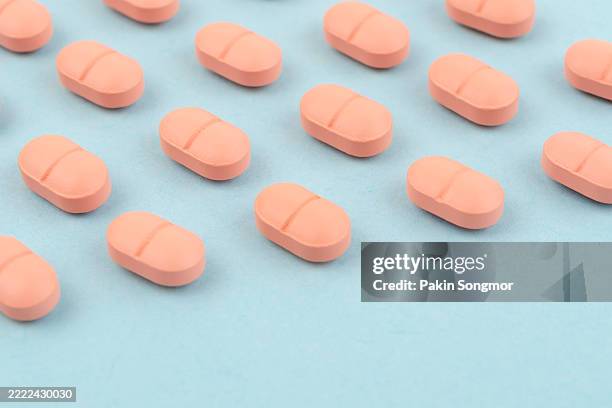 pink tablets on a blue background, healthcare and medicine concept. - birth control pill stock pictures, royalty-free photos & images