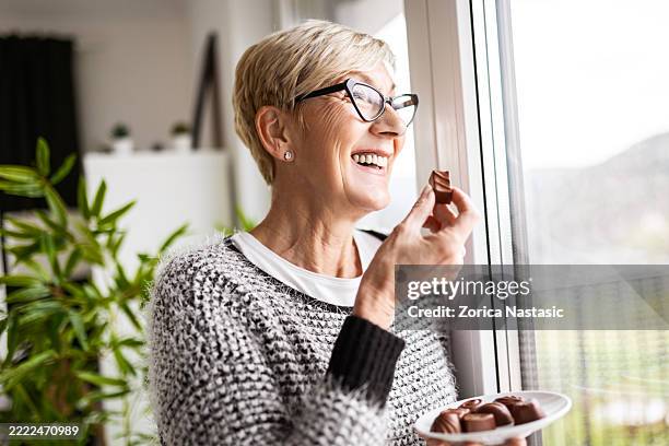 elderly woman enjoying a snack - só uma mulher idosa imagens e fotografias de stock