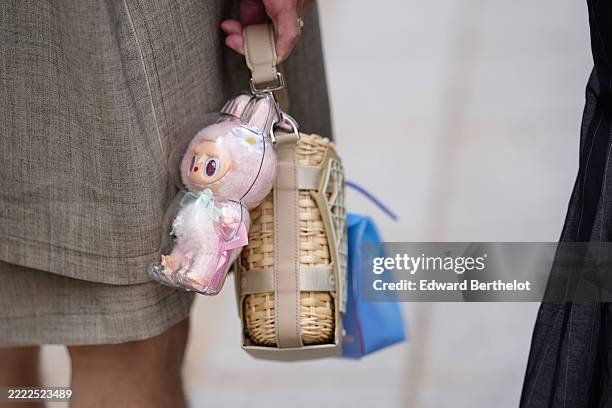 Guest wears a light gray pattern/print oversized trench coat, white dog Dior and Hylton Nel pin, silver Dior rings, light brown Dior Sahara basket...