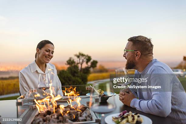 romantic dinner by fire at sunset - winery dining stock pictures, royalty-free photos & images