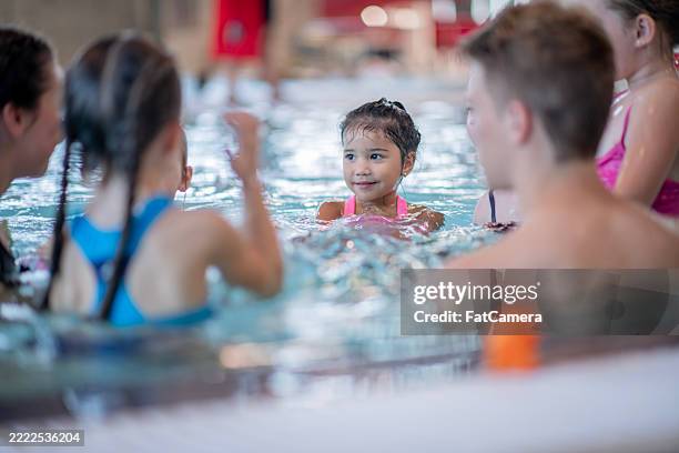 gruppe von kindern, die an einem lustigen schwimmkurs im hallenbad teilnehmen - hallenbad stock-fotos und bilder