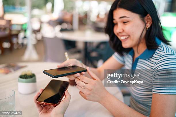 phone held over another for data transfer or payment - exchanging information stock pictures, royalty-free photos & images