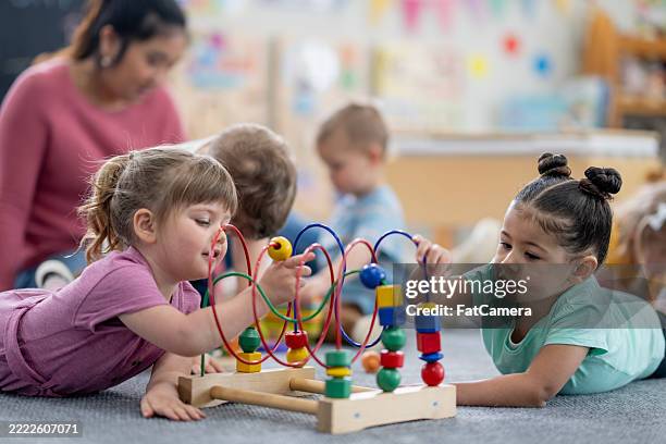 preschoolers engaging in constructive playtime with educational toys in a colorful classroom - preschool student stock pictures, royalty-free photos & images