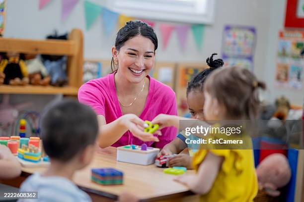 insegnante di scuola materna che si impegna con i bambini in un ambiente educativo in classe - bambino di età prescolare foto e immagini stock