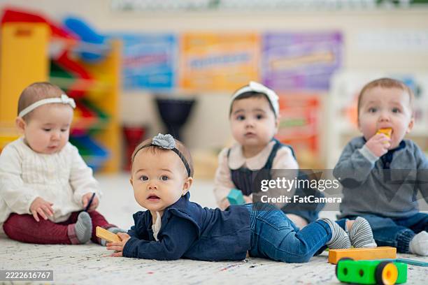 grupo de adorables bebés participan en actividades de juego en una colorida guardería - sólo bebés fotografías e imágenes de stock