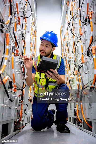 industrial technician worker maintenance checking power system at solar cell plant room. - battery storage stock pictures, royalty-free photos & images