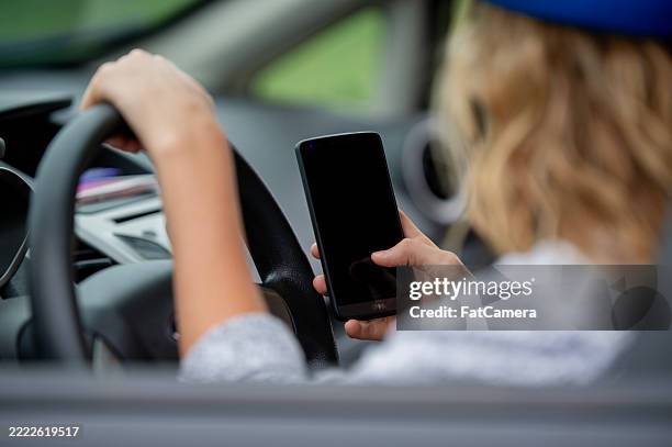 person using smartphone while driving in a modern vehicle interior - no texting and driving sign stock pictures, royalty-free photos & images