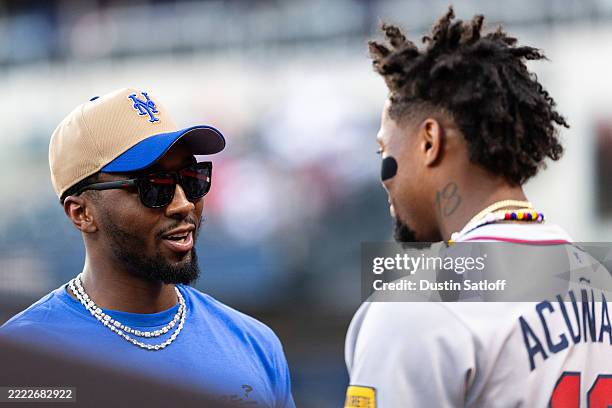 Basketball player Donovan Mitchell of the Cleveland Cavaliers speaks with Ronald Acuña Jr. #13 of the Atlanta Braves before the game against the New...