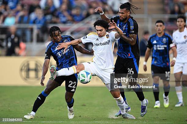 Matheus Nascimento of the Los Angeles Galaxy keeps the ball away from Rodrigues of the San Jose Earthquakes and DeJuan Jones in the first half at...