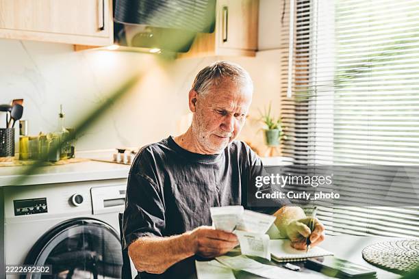 man calculates monthly expenses check receipts to pay. - monatliches ereignis stock-fotos und bilder