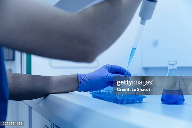 scientists conduct scientific experiments in the biosafety cabinet of the laboratory. - roupa protetora imagens e fotografias de stock