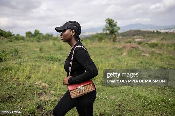 Hiker holds her bag as she climbs a hill during a group hike on the outskirts of Abuja, Nigeria, on June 28, 2025. With no trail post in sight, the...