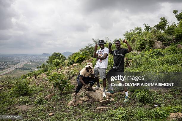 Hikers pose for a photograph at the summit of a hill during a group hike on the outskirts of Abuja, Nigeria, on June 28, 2025. With no trail post in...