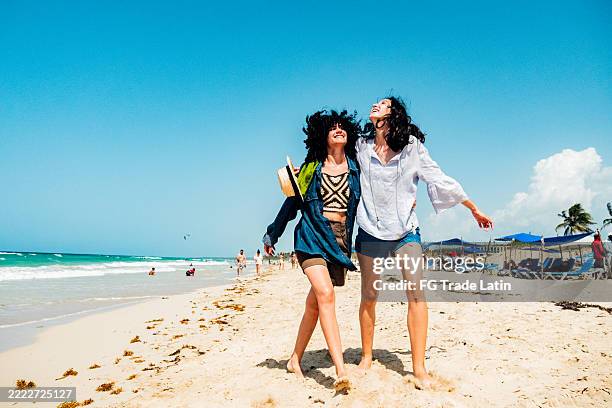 young friends women walking on the beach - beach holiday stock pictures, royalty-free photos & images