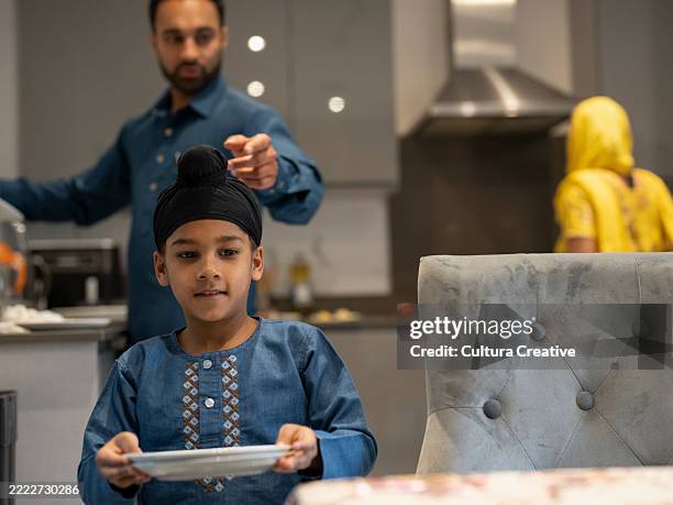 father and son (6-7) setting table together - single father stock pictures, royalty-free photos & images