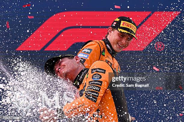 Race winner Lando Norris of Great Britain and McLaren and Second placed Oscar Piastri of Australia and McLaren celebrate on the podium with Champagne...