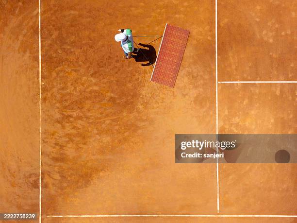 top view of male athlete smoothing clay tennis court surface - dragging stock pictures, royalty-free photos & images