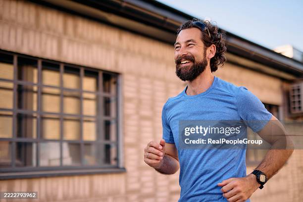 homme barbu heureux courant à l’extérieur dans la ville - barbe bleue photos et images de collection