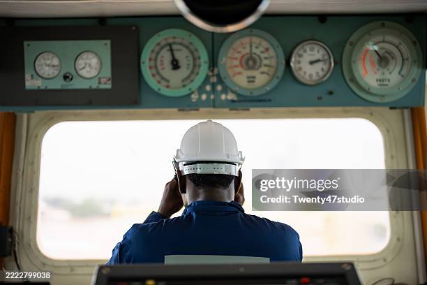 a crew is working on the bridge in the control area of a container cargo ship - boat deck stock pictures, royalty-free photos & images