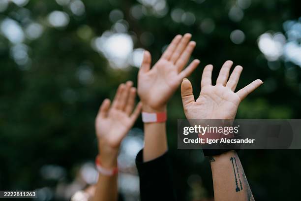 fans cheering with hands up at music festival - music festival wristband stock pictures, royalty-free photos & images