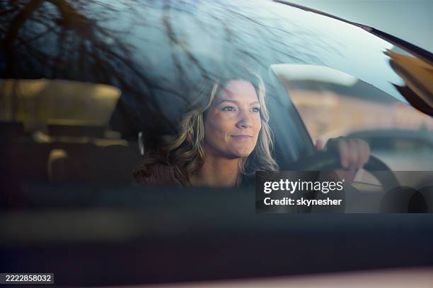 smiling woman going on a road trip by car. - windshield stock pictures, royalty-free photos & images