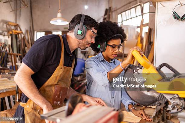 instructeur guidant l’élève dans un atelier pratique de menuiserie avec des outils électriques - menuiserie photos et images de collection