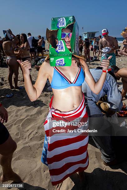 Woman is seen wearing an empty Rolling Rock beer 30-pack box on her head, at the conclusion of the annual Hermosa Ironman, an "athletic" competition,...