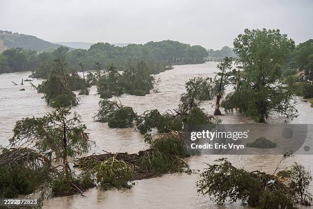 Trees emerge from flood waters along the Guadalupe River on July 4, 2025 in Kerrville, Texas. Heavy rainfall caused flooding along the Guadalupe...