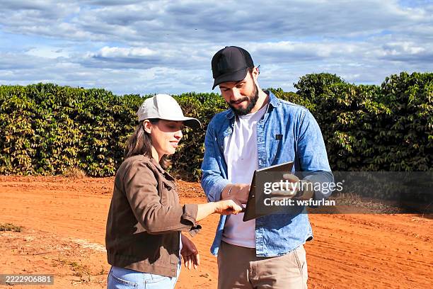 moderne landwirte arbeiten zusammen - landwirtschaftliche tätigkeit stock-fotos und bilder