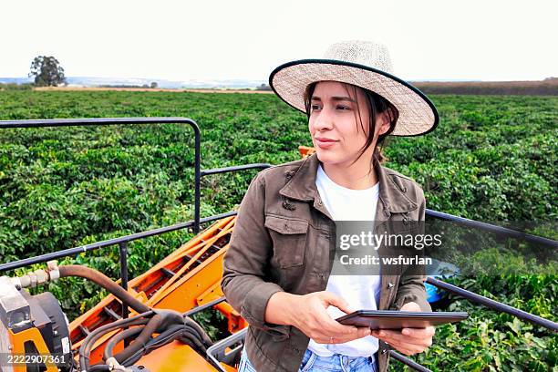 kaffeebauer nutzt technologie an der erntemaschine - landwirtschaftliche tätigkeit stock-fotos und bilder
