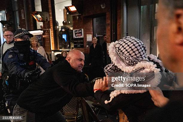 Worker of the restaurant pulls a protester towards the police. A Melbourne restaurant 'Miznon' whose owner has ties to the controversial Gaza...