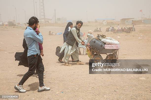 Man pushes a cart loaded with belongings at the Islam Qala border crossing in Afghanistan on July 4, 2025. Mass expulsions surged after the...