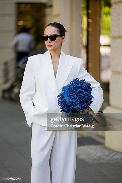 Berna Bilbey wears white Suit Mango, navy blue fringed bag Mon Blanche, sunglasses Saint Laurent during Berlin Fashion Week SS26 on June 30, 2025 in...