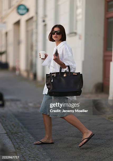 Sophia Geiss is seen wearing chunky silver hoop earrings, a silver nose ring, black aviator sunglasses from Vehla Eyewear, an oversized white...