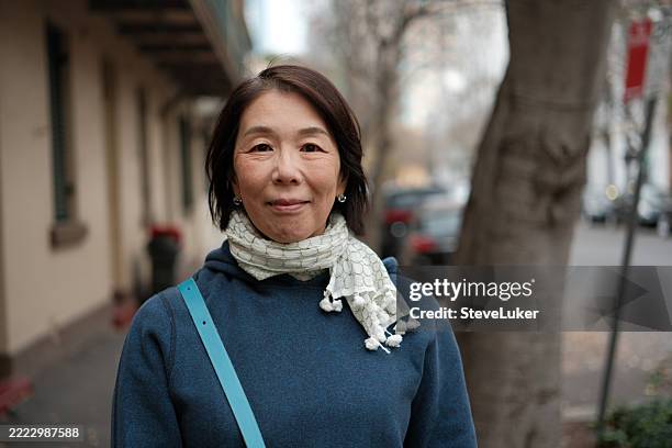 smiling woman with a scarf in a street - scarf stock pictures, royalty-free photos & images