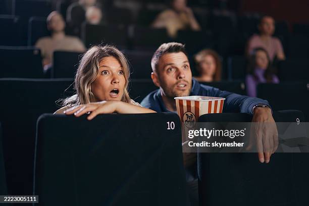 couple regardant un film d’horreur au cinéma. - scary movie theatre photos et images de collection