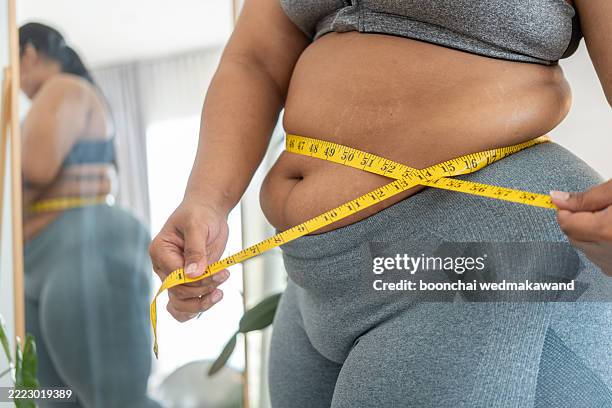 obese woman with fat upset about her belly. overweight woman touching his fat belly and want to lose weight. fat woman worried about weight diet lifestyle - obesity stock pictures, royalty-free photos & images