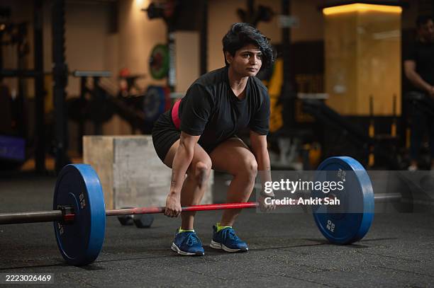 female performing deadlift exercise with weight bar - deadlift stock pictures, royalty-free photos & images