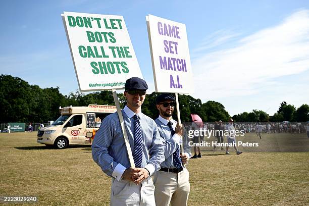 People dressed as line judges protest against the hawkeye camera technology introduced this year for line calling on day two of The Championships...