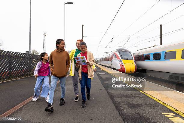 multiracial family walking together at railway station - family day stock pictures, royalty-free photos & images