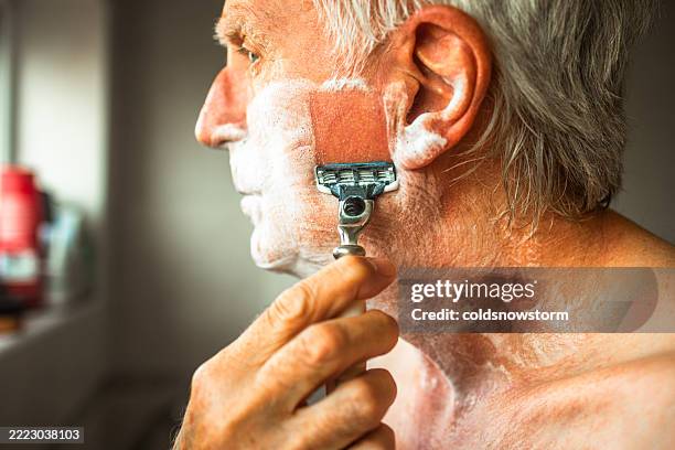 afeitado húmedo para hombre mayor con maquinilla de afeitar y crema de afeitar - crema de afeitar fotografías e imágenes de stock