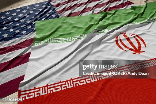 American and Iranian flags resting on desert sand American and Iranian flags resting on desert sand