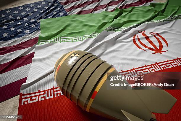 illustrations, cliparts, dessins animés et icônes de nuclear bomb, american and iranian flags resting on desert sand - états unis