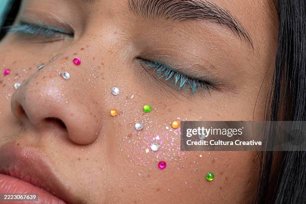 close up of woman with closed eyes with colorful shiny freckles - glitter face stock pictures, royalty-free photos & images