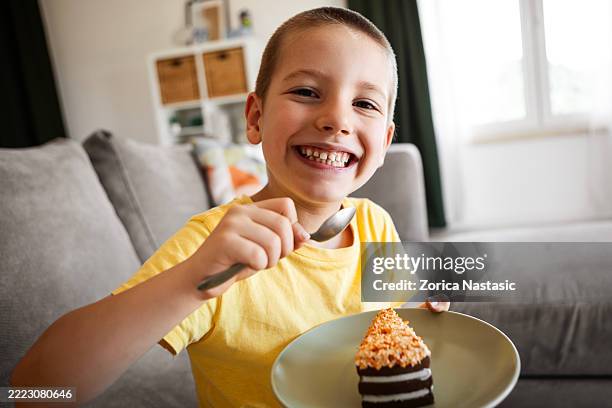 happy little boy enjoying a slice of cake - small slice cake stock pictures, royalty-free photos & images