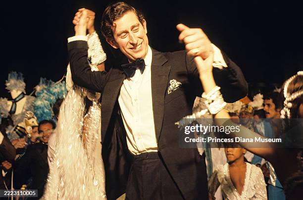 Carnival performer Pinah Ayoub and Prince Charles, Prince of Wales , with an unidentified woman, samba dance during a street party at the Town Hall,...