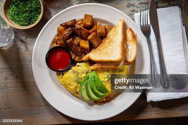 top down angle of a vegetarian omelette with avocado and home fries. - stuffed avocado stock pictures, royalty-free photos & images